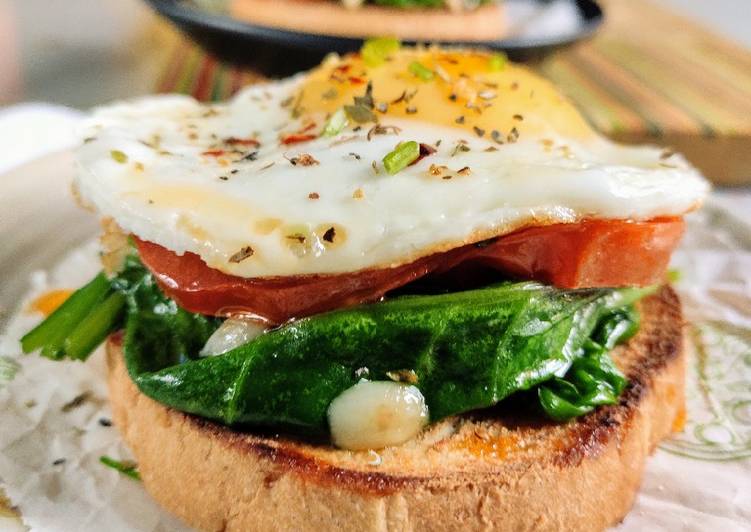 Sunny side up eggs with garlic spinach and roasted tomato