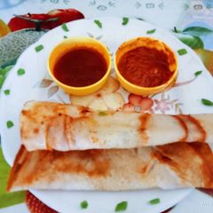 A picture of Instant tasty and crispy butter dosa with red chutney.