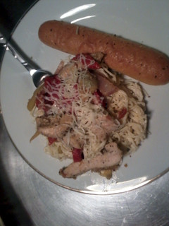 A picture of italian chicken with angel hair pasta in a creamy artichoke primavera.