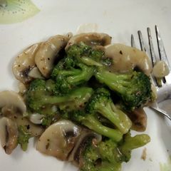A picture of Broccoli and mushroom in garlic sauce.