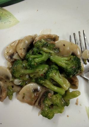 A picture of Broccoli and mushroom in garlic sauce.
