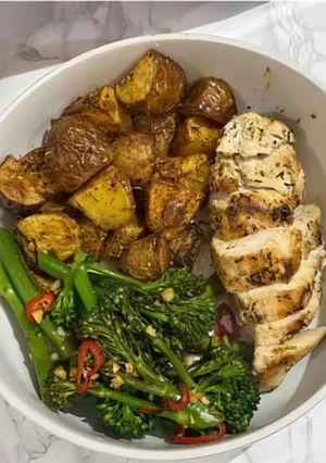 A picture of Garlic chicken, potatoes and greens.