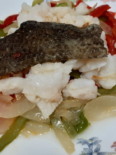 Una foto de Bacalao desmigado con fritada de pimientos y cebolla