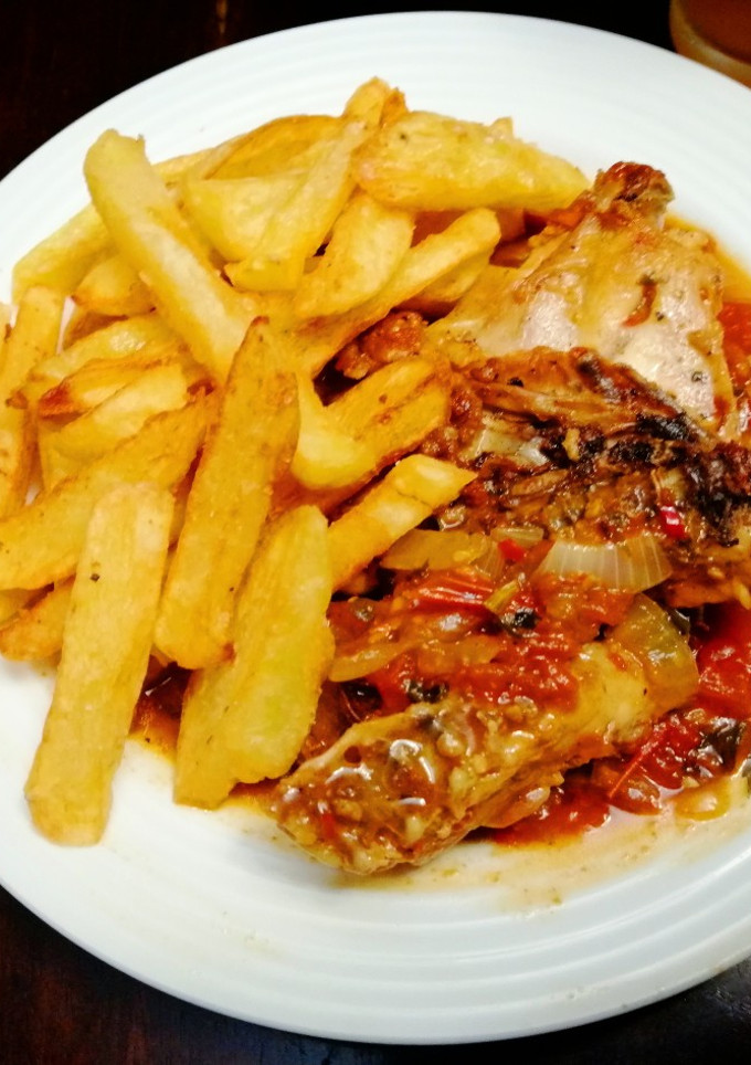 Una foto de Pollo Frito en Gravy de Tomate y Papas Inglesas