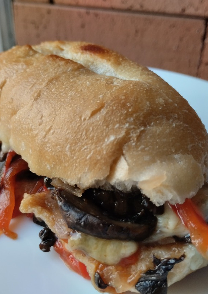 Una foto de Sándwich🧅🥖🌶️de champiñones con pimiento, cebolla y salsa bbq🧀🍯🍄