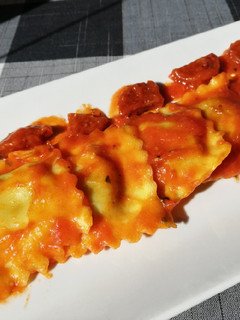 Una foto de Ravioli 🥟 rellenos de requesón y espinacas en salsa