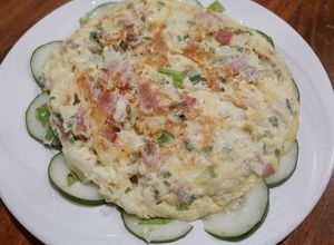 Una foto de Tortilla de jamón y queso sobre lecho de vegetales