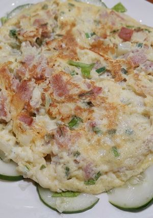 Una foto de Tortilla de jamón y queso sobre lecho de vegetales
