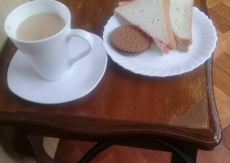 Cup of tea, slice of buttered n jam bread n a chocolate cookie