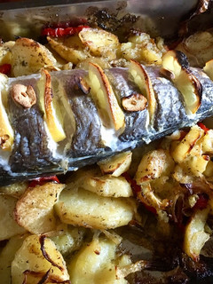 Una foto de Cola de merluza con patatas pimientos rojos y cebolla cebolla