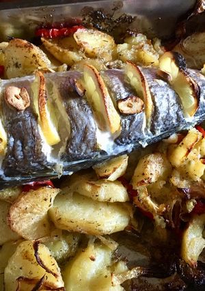 Una foto de Cola de merluza con patatas pimientos rojos y cebolla cebolla