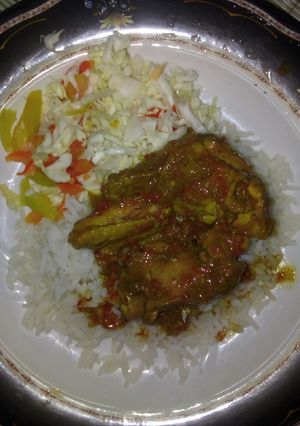 A picture of White rice and chicken sauce.