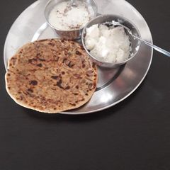 A picture of Onion pratha with curd and butter.