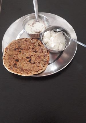 A picture of Onion pratha with curd and butter.