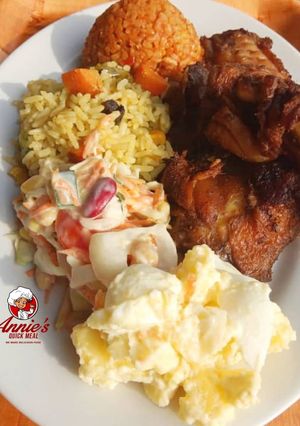 A picture of Fried rice,Jollof rice,Fried chicken, Potatoe Salad and coleslaw.