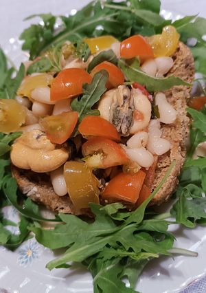Foto di Frisella integrale con cozze, fagioli pomodorini e rucola