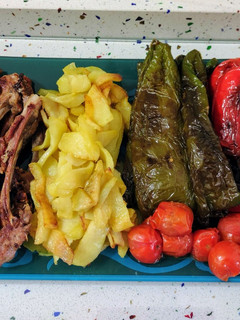 Una foto de Chuletillas de cordero y tomatitos con patatas y pimientos fritos