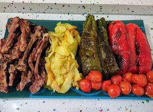 Una foto de Chuletillas de cordero y tomatitos con patatas y pimientos fritos