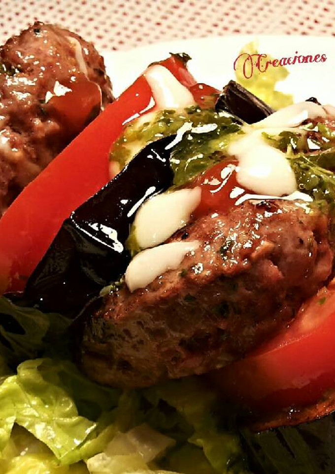 Una foto de Hamburguesas de solomillo de ternera, con tomates, berenjenas y vinagreta de albahaca