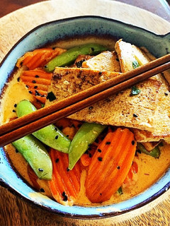 A picture of Thai Red Curry Coconut with Pan Fried Tofu, Snap Peas & Carrots over Rice.