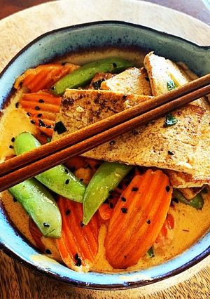 A picture of Thai Red Curry Coconut with Pan Fried Tofu, Snap Peas & Carrots over Rice.