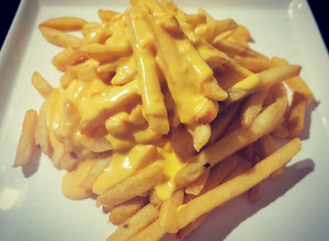 Una foto de Papas con salsa cheddar