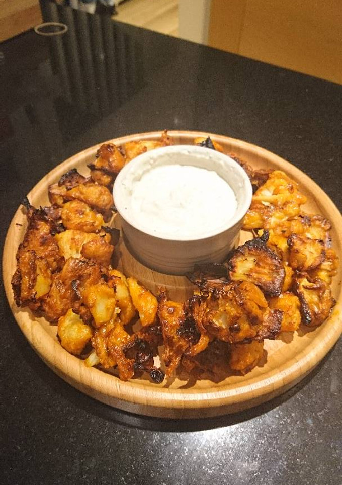 A picture of Buffalo cauliflower wings with blue cheese dip.
