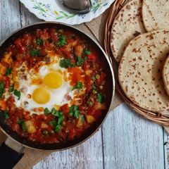 A picture of Shakshuka (In my style- Poached eggs in tomato and veggie gravy).