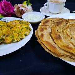 A picture of Omlat lacha paratha and chaye.