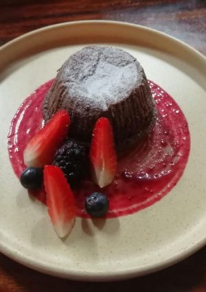 Una foto de Lava cake con salsa de frutos rojos