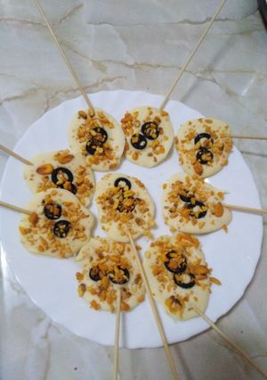 Una foto de Piruletas de chocolate blanco con maíz frito y aceituna negra