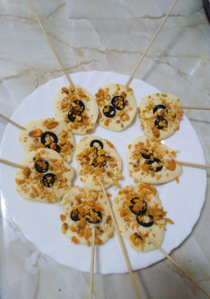 Una foto de Piruletas de chocolate blanco con maíz frito y aceituna negra