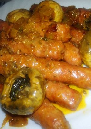 Una foto de Salchichas frescas en salsa de vino con champiñones