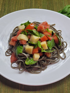 Una foto de Fettuccini tinta de calamar con caprese
