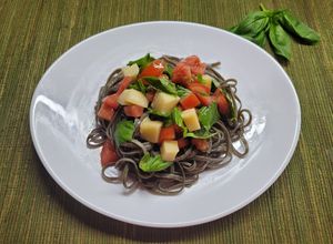 Una foto de Fettuccini tinta de calamar con caprese