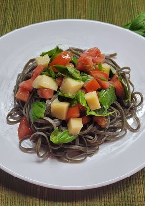 Una foto de Fettuccini tinta de calamar con caprese