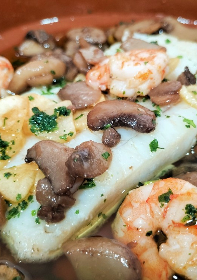 Una foto de Bacalao con champiñón y langostinos al ajillo