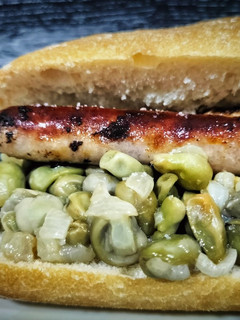 Una foto de Bocadillo de longanizas con habitas y cebolla confitadas