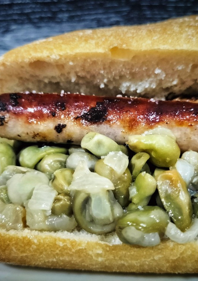 Una foto de Bocadillo de longanizas con habitas y cebolla confitadas