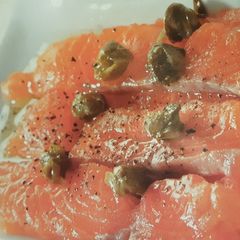 A picture of Salmon carpaccio with lemon dressing.