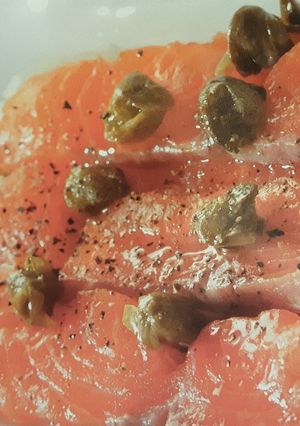 A picture of Salmon carpaccio with lemon dressing.