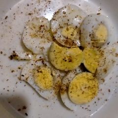 A picture of Boiled egg with salt and pepper.