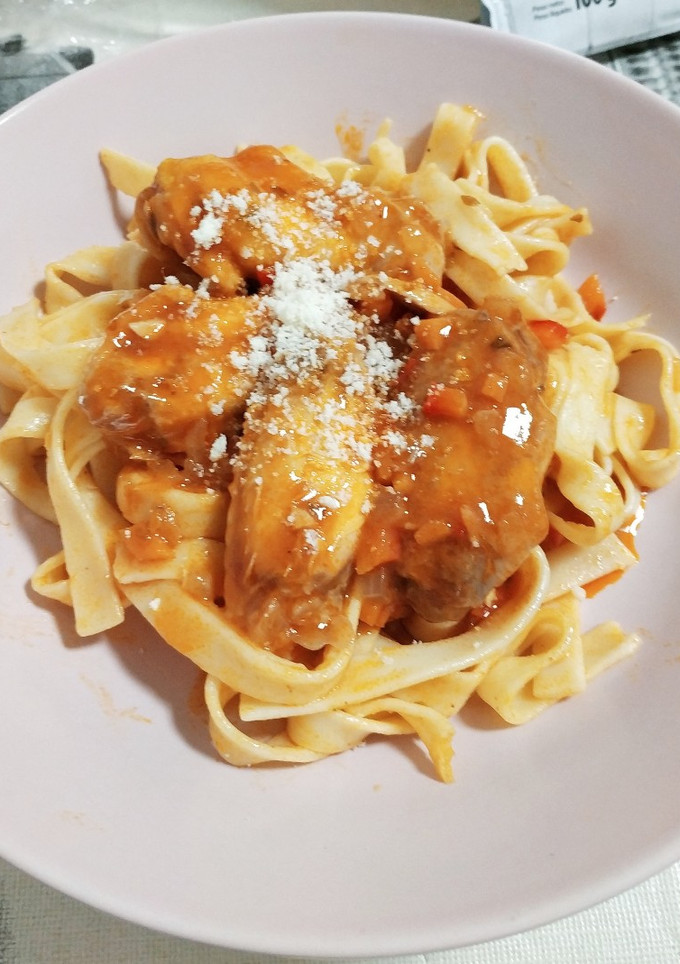 Una foto de Fideos al huevo con alitas de pollo en salsa de tomate