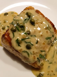 A picture of Pan-seared salmon with white wine and caper sauce.