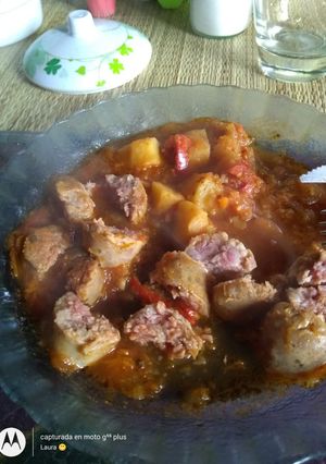 Una foto de Chorizos de cerdo a la pomarola con papas y zapallo