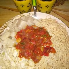 A picture of Spaghetti with yam and stew.....garnished with cabbage.