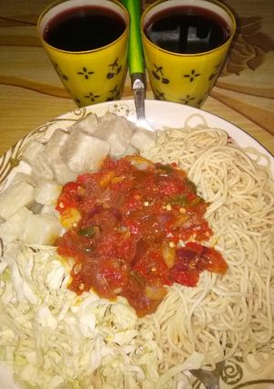 A picture of Spaghetti with yam and stew.....garnished with cabbage.