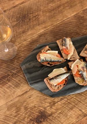 A picture of Sardine, butter, lemon, tomato & pepper on toast.