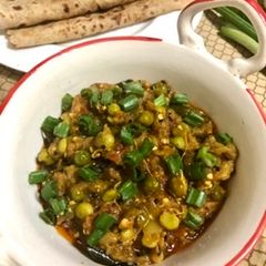 A picture of Baingan bharta with green peas.
