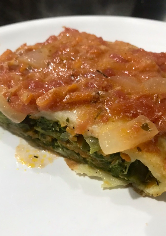 Una foto de Canelón gigante de acelga y zanahoria, con tapa de tarta